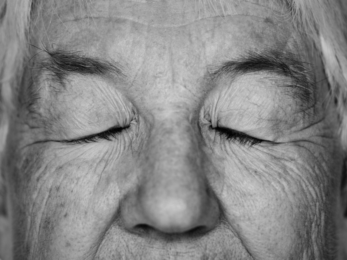 Femme âgée, yeux fermés, en noir et blanc. Par rawpixel.com. Licence Freepik / https://fr.freepik.com/photos-gratuite/portrait-noir-blanc-femme-agee-blanche-yeux-fermes_18920666.htm#page=1&query=vieillesse&position=29&from_view=search/