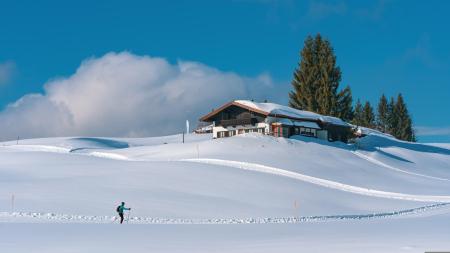 Skieur passant devant un chalet. Par Chiem Seherin. https://pixabay.com/fr/photos/hiver-saison-la-nature-en-plein-air-7006310/